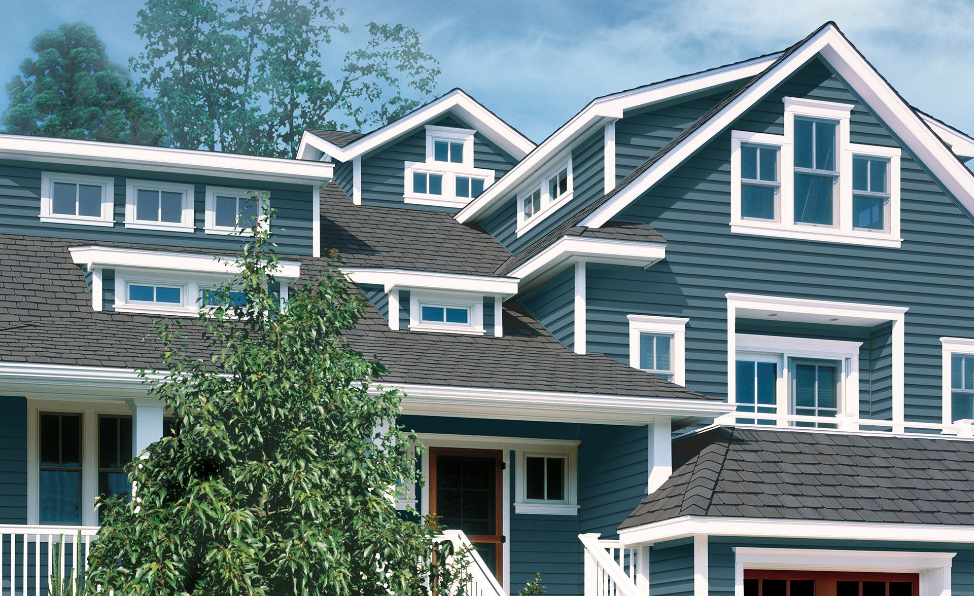 Large home with blue siding and many windows 