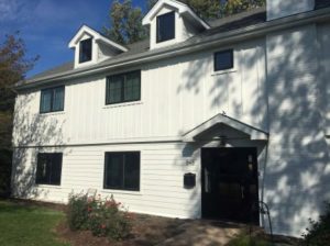 White home lined with black windows 